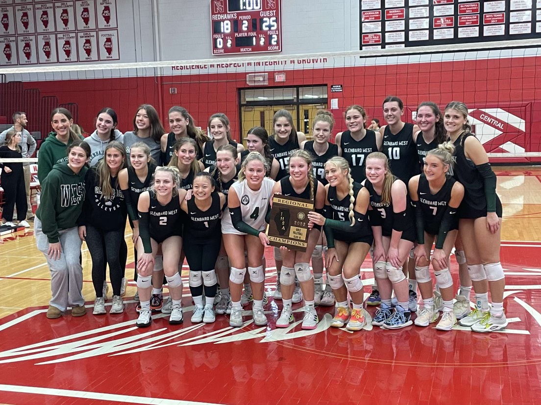 The+team+celebrates+their+regional+victory%2C+hoisting+the+plaque.+After+closing+out+25-18+in+the+second+set+to+sweep+Naperville+Central.