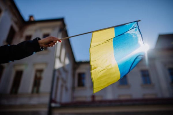 People holding the Ukrainian Flag and protest against Russian Invation in Ukraine in the streets. Photo aquire from Getty Images.